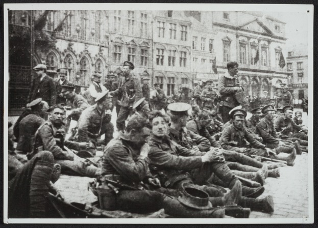 Soldats britanniques du 4e Royal Fusiliers se reposant le 23 août 1914 lors de leur retraite sur la Grand’Place de Mons, venant de Nimy, ils descendront la ville par la rue de la Chaussée.  Collection du Mons Memorial Museum, Propriété de la Ville de Mons.